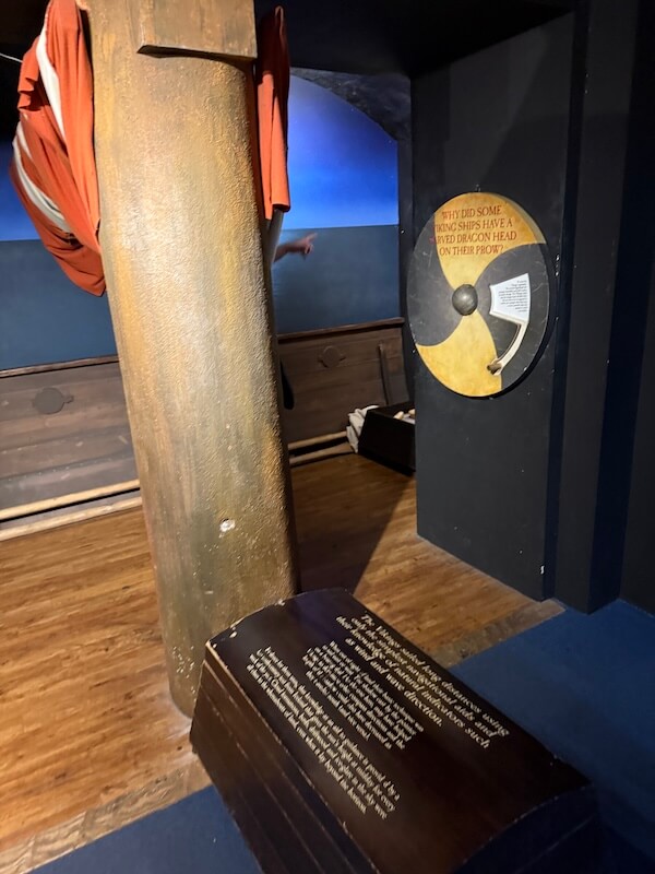 A wooden replica of a Viking ship’s prow with interpretive panels discussing the use of dragon heads on ships.