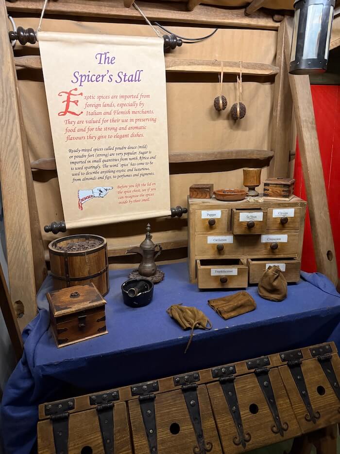 Describes how exotic spices were imported and used, featuring replica spice containers and trade goods.