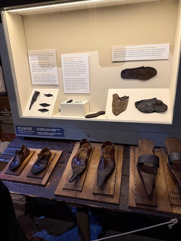 Displays leather shoes and wooden molds used in medieval Dublin, showcasing historical craftsmanship.