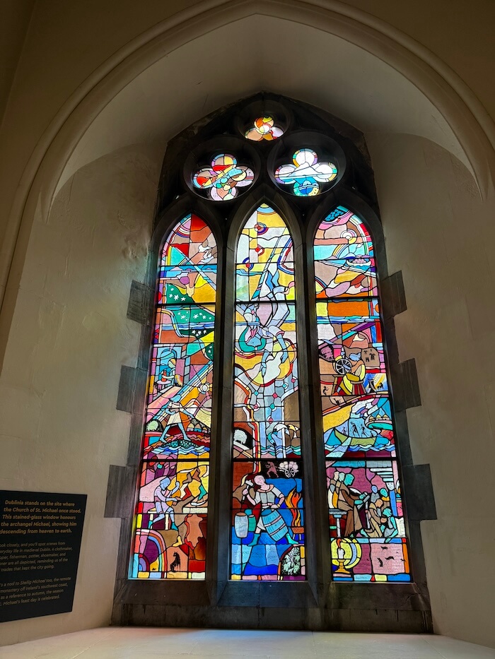 A vibrant stained-glass panel within the museum, likely depicting religious or historical scenes from medieval Dublin.